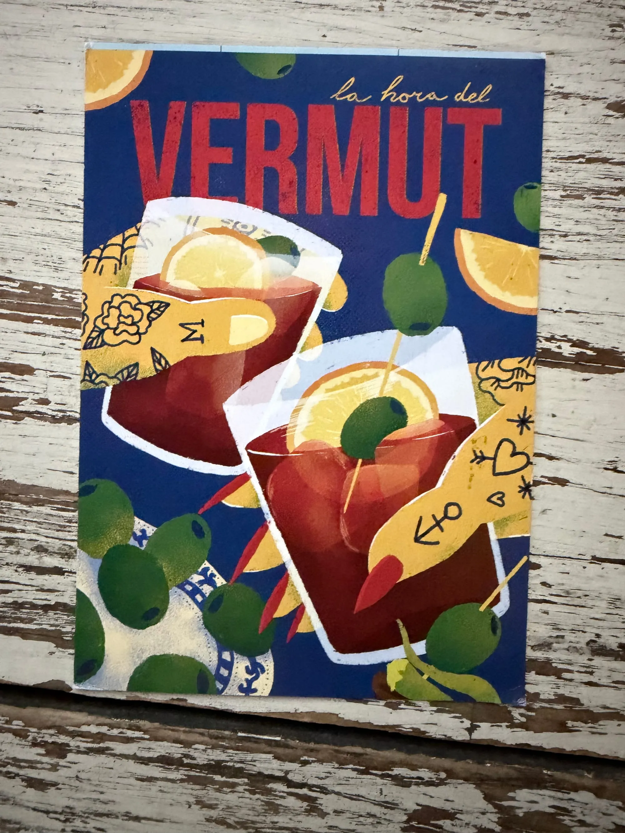 An image of a postcard, with two glasses of a drink being cheersed by hands, the title of the postcard is 'Vermut'